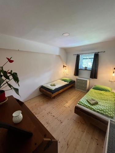 a room with two beds and a desk and a table at Apartmány2 - Náhlov in Frymburk