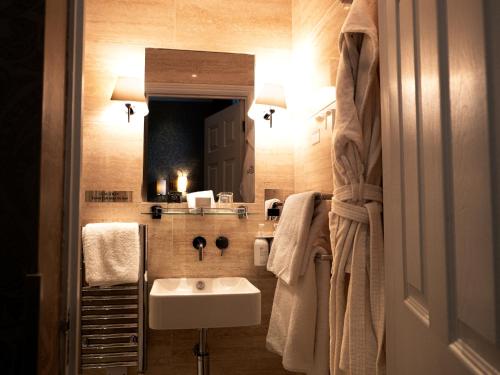 a bathroom with a sink and a mirror at St Michael's Manor Hotel - St Albans in St. Albans