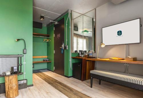 a bathroom with green walls and a sink and a bench at MeStyle Museum Hotel in Bangkok