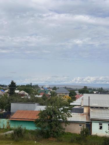 a group of buildings with mountains in the background at Alcha Hotel Karakol in Karakol