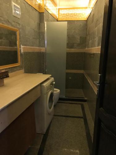 a bathroom with a toilet sink and a washing machine at Guest House in Luxor