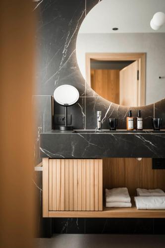 a bathroom with a sink and a mirror at Alpenheim Charming & Spa Hotel in Ortisei