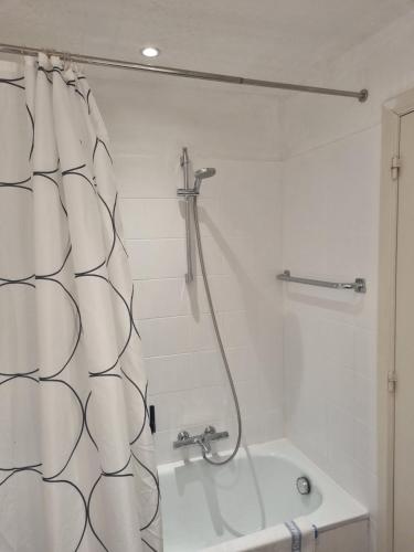 a white bathroom with a shower and a bath tub at SeaStay - vernieuwde badkamer en interieur living in Knokke-Heist