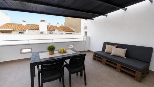 a dining room with a table and a bench at Apartaments l'Escala Centre in L'Escala