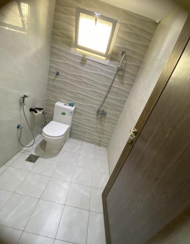 a bathroom with a toilet and a window at شقة راقية 3 غرف نوم وصالة ومطبخ وحمامين حي باقدو a1 in Medina