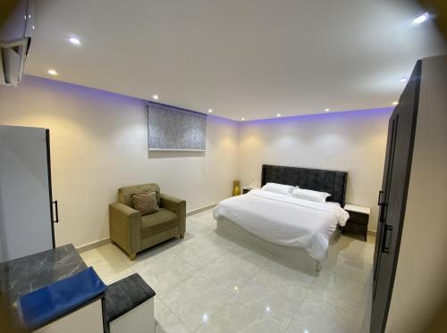a bedroom with a bed and a chair at شقة راقية 3 غرف نوم وصالة ومطبخ وحمامين حي باقدو a1 in Medina