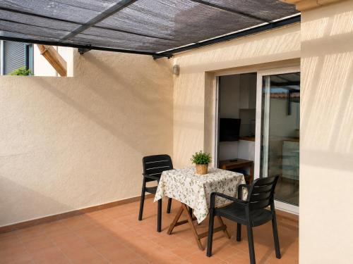 a patio with a table with chairs and a potted plant at Apartaments l'Escala Centre in L'Escala