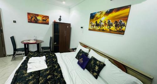 a bedroom with a bed with a painting on the wall at Pandorax Hotel Oluku in Benin City
