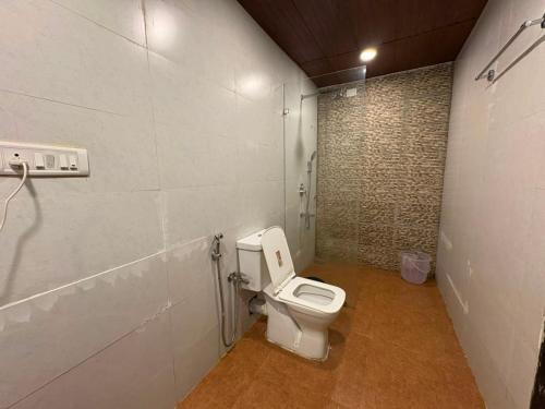 a bathroom with a white toilet in a room at Tvessa-A Boutiqe Hotel in Mandrem