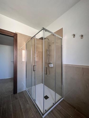 a glass shower stall in a room with wooden floors at Panorama Rooms in Gesualdo