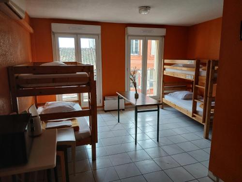 a room with two bunk beds and a table at La Petite Auberge de Saint-Sernin in Toulouse