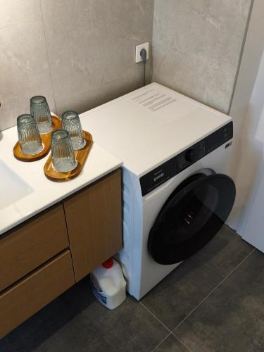 a washing machine with three dishes on top of it at Forest Hill Apartment, near Ljubljana in Dol pri Ljubljani