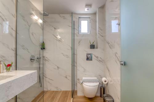 a bathroom with a glass shower and a toilet at Castro Beach Hotel in Maleme