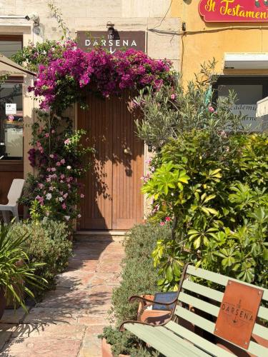 a green bench sitting in front of a building with flowers at Indarsena b&b in Portoferraio