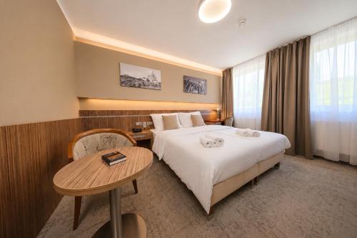 a hotel room with a bed and a table at Hotel Vaka in Brno