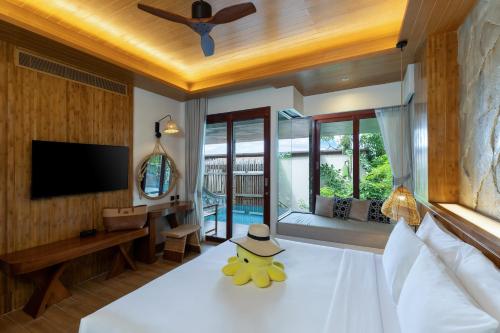 a bedroom with a bed with a hat on it at SINAE Phuket Luxury Hotel in Phuket