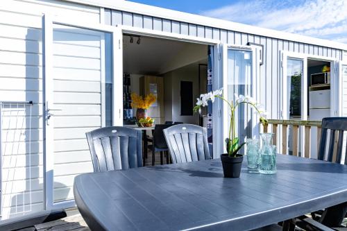 a table and chairs on a porch with a table and a dining room at Kustpark Nieuwpoort in Nieuwpoort