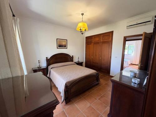a bedroom with a bed and a table and a window at Finca La Talona, piscina in Cádiz