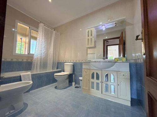 a bathroom with a sink and a toilet and a mirror at Finca La Talona, piscina in Cádiz