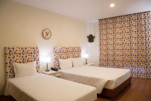 a hotel room with two beds and a wallpaper at Hotel A.S. Lisboa in Lisbon