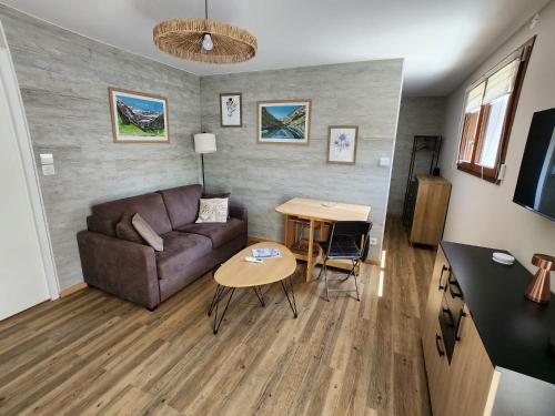 a living room with a couch and a table at la perle du pibeste in Agos-Vidalos