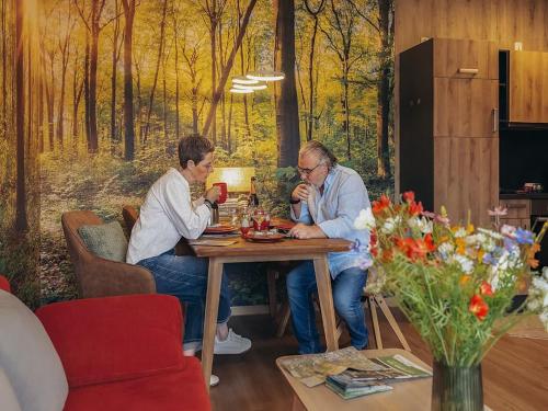 two people sitting at a table in a living room at Apartment Hainich in Mühlhausen
