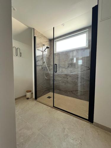a shower with a glass door in a bathroom at Maison Hyper-centre Dinard - Garage privé - 200 M plage in Dinard