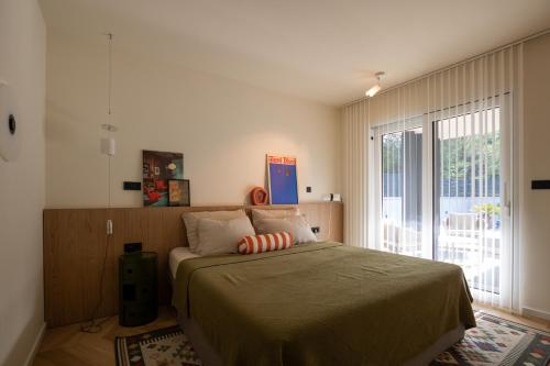 a bedroom with a bed and a large window at Casa Palmera in Pridraga