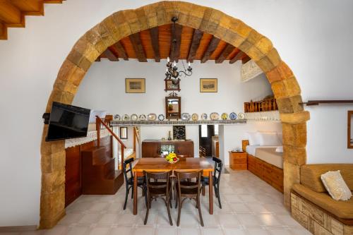 a dining room with a table and chairs and a bed at IOANNAS ARCH HOUSE a in Gennadi