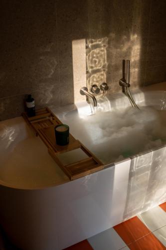a bath tub with a sink with a cup in it at Casa Palmera in Pridraga