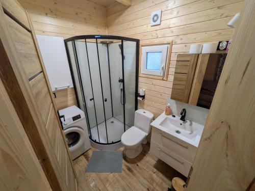 a bathroom with a shower and a toilet and a sink at Domki Przydwórz in Przydwórz