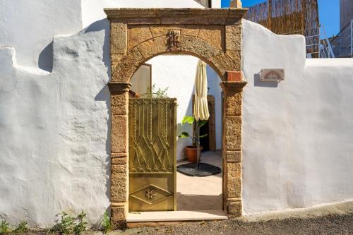 an archway with a door in a white wall at IOANNAS ARCH HOUSE a in Gennadi