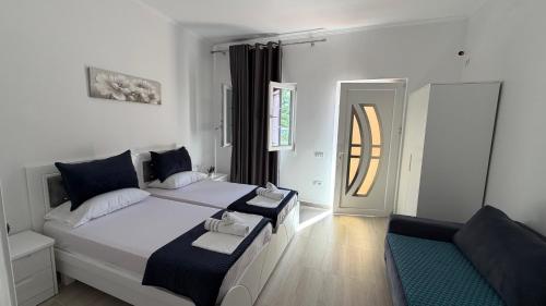 a bedroom with a bed and a chair in it at Amel's Apartments Comfortable Family Stay Near Orikum Beach in Orikum