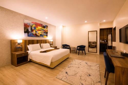 a hotel room with a bed and a desk and a room at Jalo Hotel - Shashemene in Shashemenē