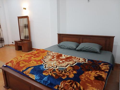 a bedroom with a bed with a colorful comforter at Siriliya Homestay - Foreign Tourists Only in Nuwara Eliya