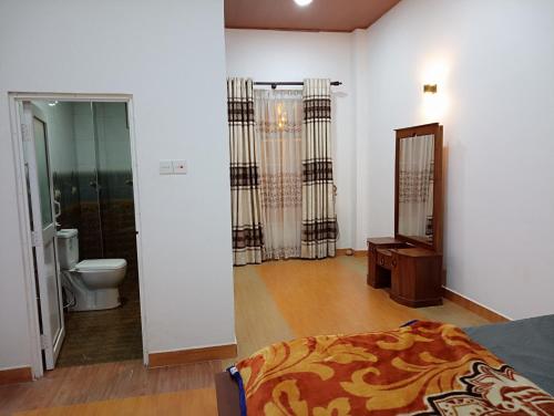 a bedroom with a bed and a toilet and a mirror at Siriliya Homestay - Foreign Tourists Only in Nuwara Eliya