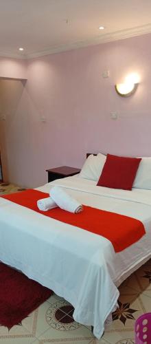a bedroom with two beds with red and white sheets at Royal pine cottage hotel in Ruiru