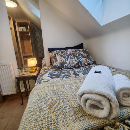 a bedroom with a bed with towels on it at Outlander Boutique B&B ONLY ADULT Suite in Cruden Bay