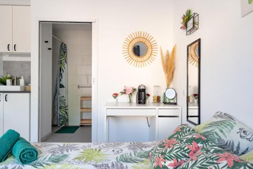 a room with a bed and a vanity with a mirror at Chambres D'hotes Le Cocon De Lily in Saint-Avit