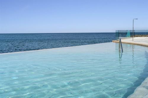 a swimming pool with the ocean in the background at Barceló Praia Cape Verde in Praia