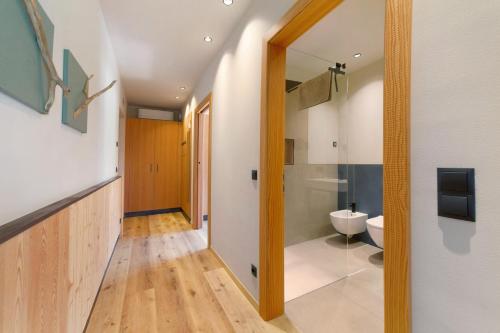 a hallway with a bathroom with a toilet and a mirror at Apartment Oberhaslerhof in Schenna