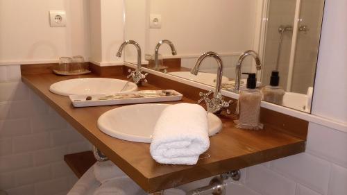 a bathroom with two sinks and two mirrors at Posada Casa Fidela in Lomeña
