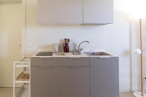 a white kitchen with a sink and a counter at Case Luparello in Marzamemi