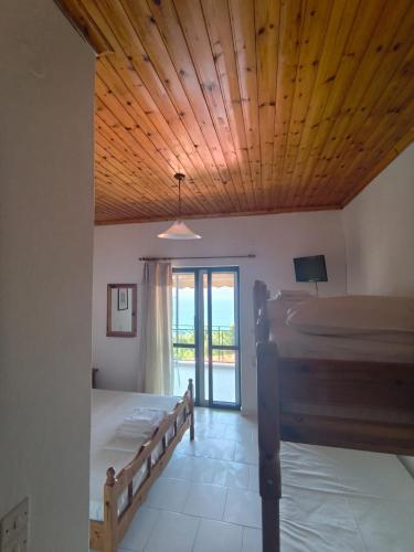a bedroom with two beds and a wooden ceiling at Paradisos in Loutsa