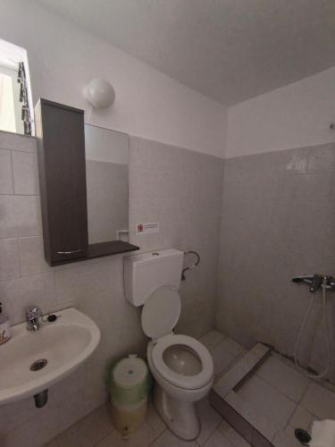 a bathroom with a white toilet and a sink at Paradisos in Loutsa