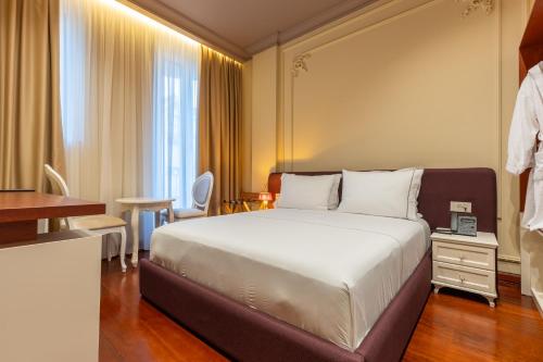 a hotel room with a bed and a window at Vatër Hotel in Shkodër