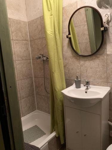 a bathroom with a sink and a shower with a mirror at Apartamenty w Kamienicy in Reszel