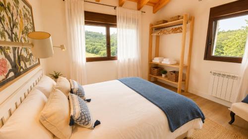 a bedroom with a bed and a window at La Cuadra de San Pedro Ribadesella in Ribadesella