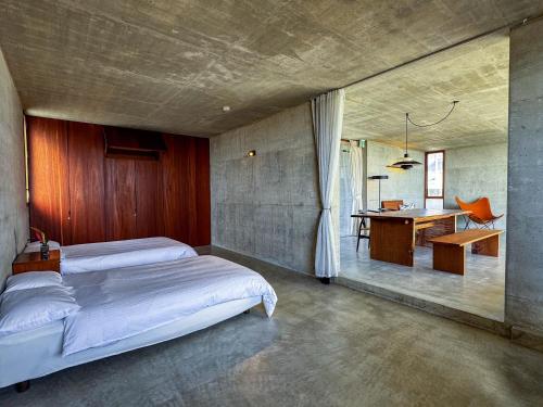 a bedroom with a bed and a desk in it at 大木の宿 Shicari in Yomitan