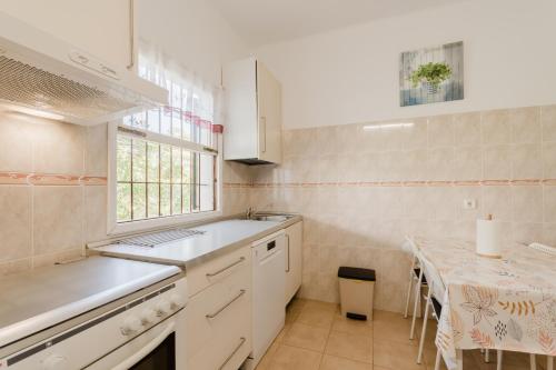 a kitchen with a sink and a table and a window at Holiday Home Kety in Portals Nous